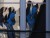 Ombres chinoises de gens attendant sur un quai de train de banlieue, reflétées dans une fenêtre.